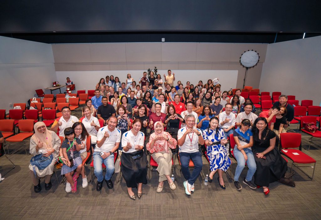 Participants of CaringSG's Family Day Talks with Guest-of-Honour, Mdm Rahayu Mahzam (seated, front centre in pink), CaringSG leaders and invited speakers